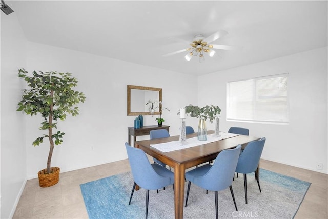 dining space with ceiling fan and tile patterned flooring