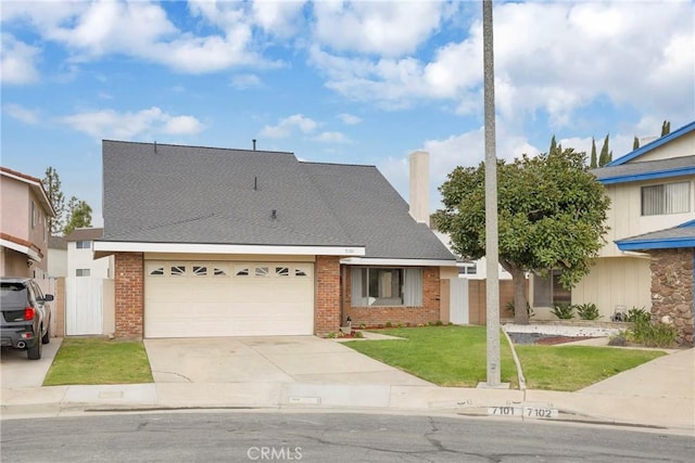 view of front of property with brick siding, driveway, a front yard, and a garage