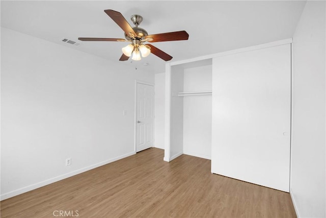 unfurnished bedroom featuring visible vents, baseboards, ceiling fan, light wood-style floors, and a closet