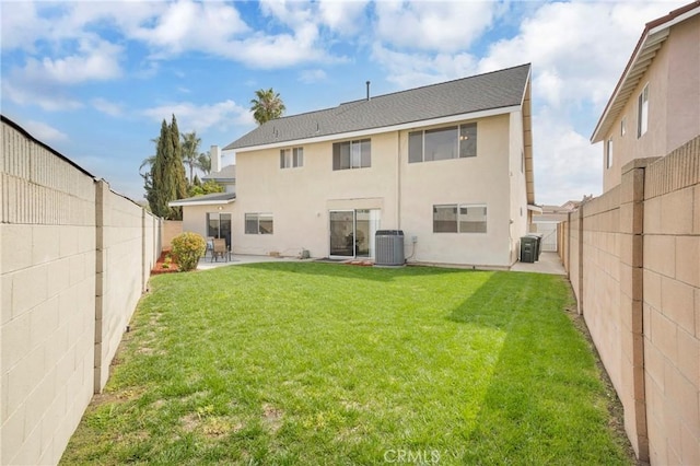 rear view of house featuring a lawn, central AC, a fenced backyard, and stucco siding