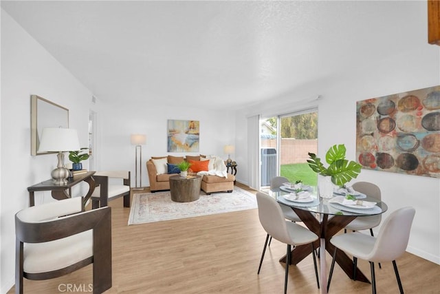 dining area featuring light wood-style flooring and baseboards