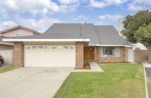 view of front facade with brick siding, a front yard, a garage, and fence