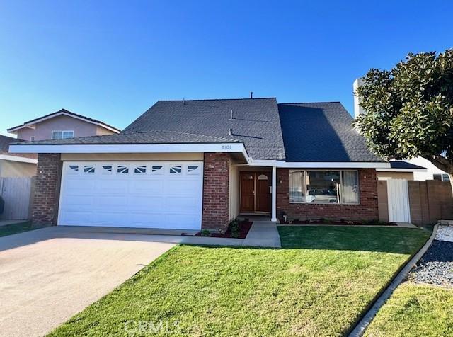 view of front of property featuring fence, driveway, a front lawn, a garage, and brick siding