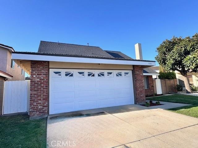 ranch-style home with an attached garage, fence, brick siding, and driveway