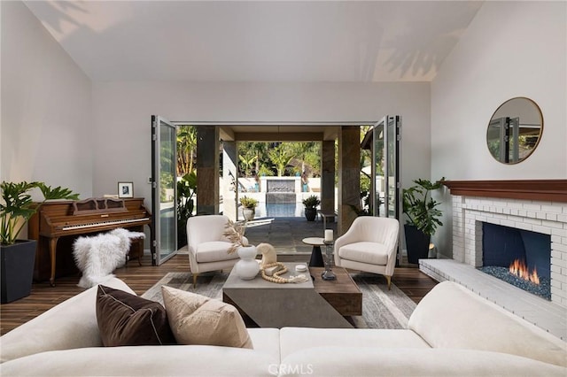 living room with wood finished floors, a fireplace, and vaulted ceiling