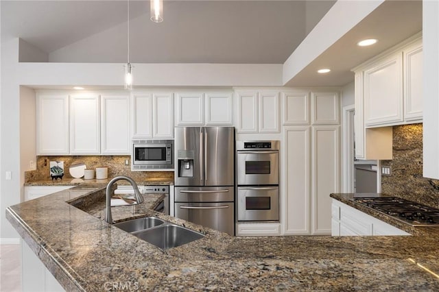 kitchen featuring decorative backsplash, white cabinets, appliances with stainless steel finishes, and a sink