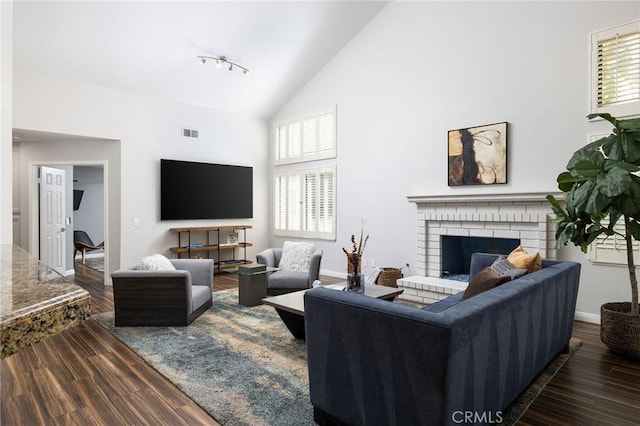 living area featuring dark wood-style floors, plenty of natural light, and visible vents