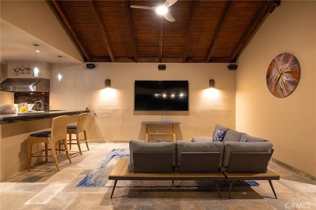 home theater with stone finish floor, wooden ceiling, vaulted ceiling with beams, and baseboards