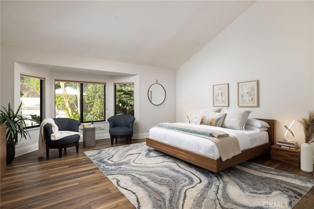 bedroom featuring baseboards, lofted ceiling, and wood finished floors