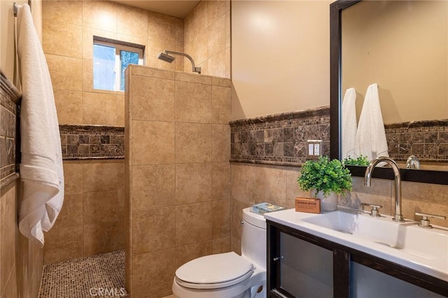 bathroom featuring toilet, tile walls, vanity, and walk in shower