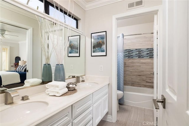 ensuite bathroom with double vanity, visible vents, crown molding, and a sink