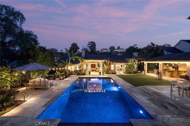 outdoor pool featuring area for grilling, a lawn, outdoor lounge area, and a patio