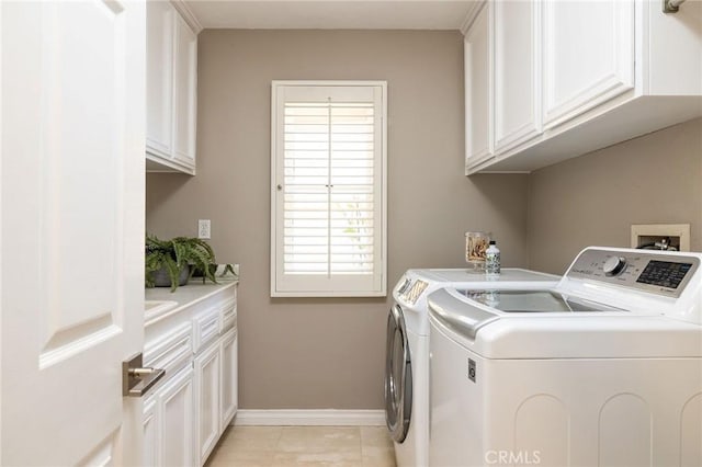 laundry room with baseboards, cabinet space, light tile patterned flooring, and washing machine and clothes dryer