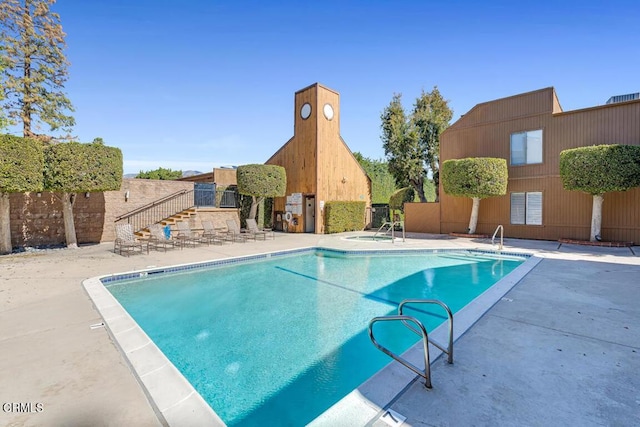 community pool with fence and a patio