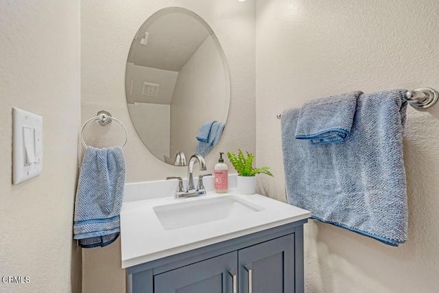 bathroom with a textured wall and vanity