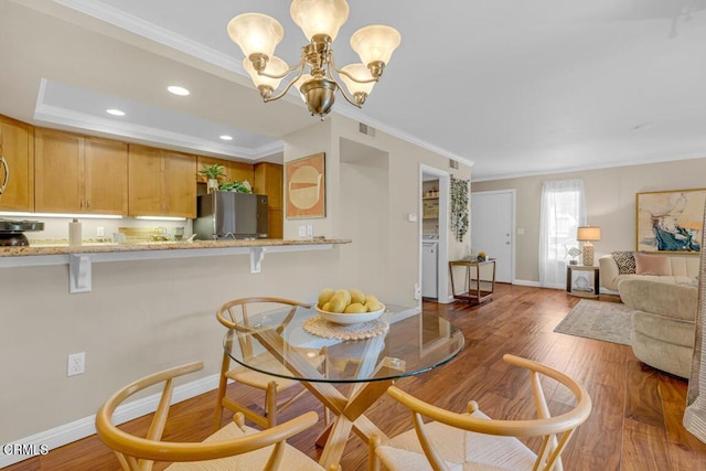 dining area with baseboards, visible vents, wood finished floors, crown molding, and recessed lighting