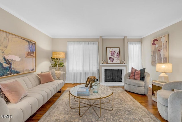 living room featuring a fireplace, plenty of natural light, wood finished floors, and crown molding