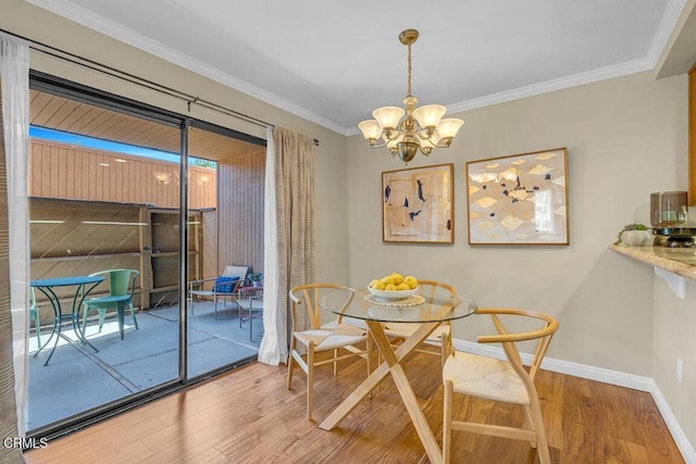 dining area with an inviting chandelier, crown molding, baseboards, and wood finished floors