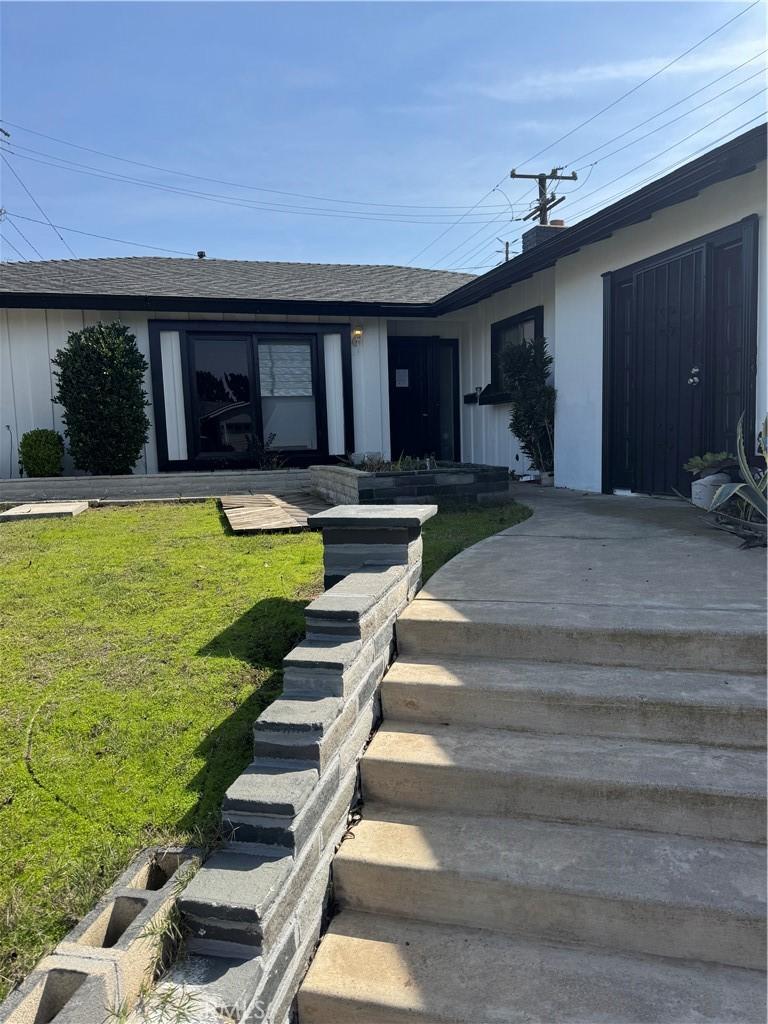 view of front of property featuring a shingled roof and a front lawn