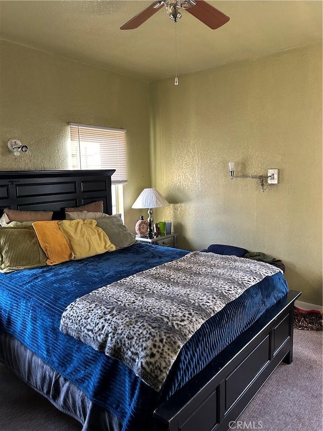 bedroom featuring carpet floors, a textured wall, and ceiling fan