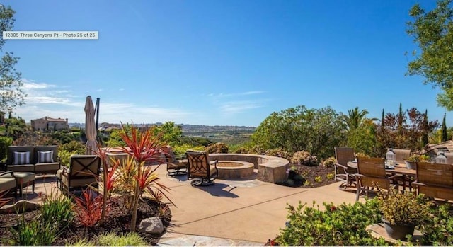 view of patio with an outdoor living space with a fire pit