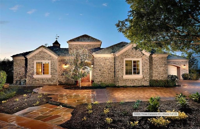 view of front of property with a garage and stone siding