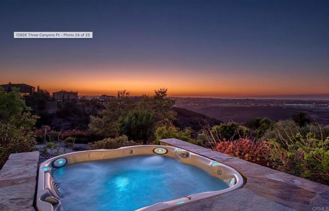 pool at dusk with hot tub deck surround