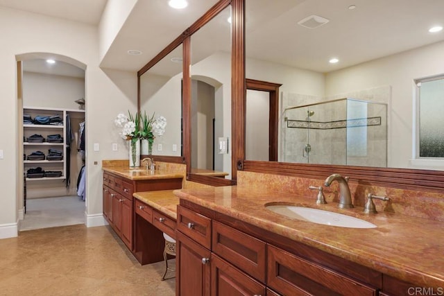 bathroom with a spacious closet, a stall shower, vanity, and recessed lighting