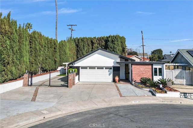 ranch-style home featuring an attached garage, fence, driveway, a gate, and stucco siding