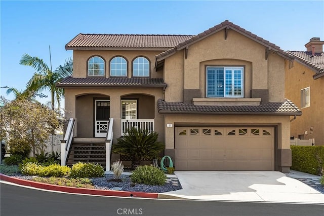 mediterranean / spanish-style home featuring covered porch, a tiled roof, an attached garage, and stucco siding