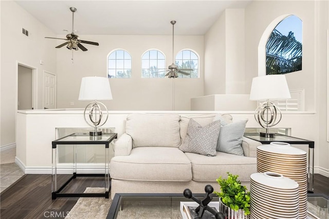 living room with visible vents, baseboards, a ceiling fan, and wood finished floors