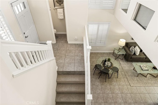 staircase featuring tile patterned floors and baseboards
