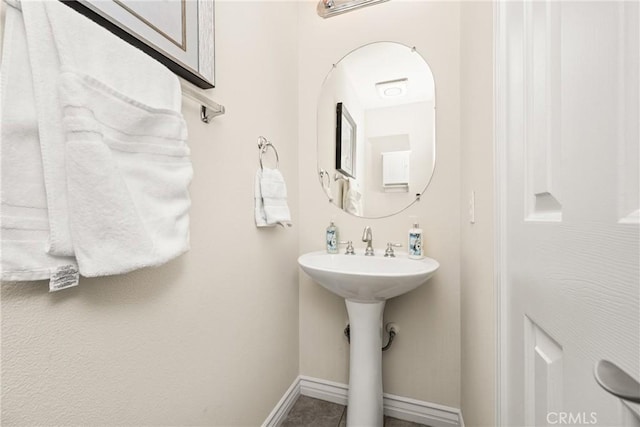 bathroom featuring baseboards and a sink