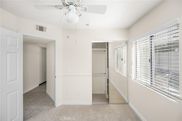 unfurnished bedroom with visible vents, a closet, carpet flooring, baseboards, and ceiling fan
