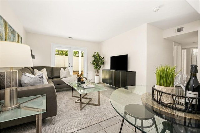 living room featuring french doors, baseboards, visible vents, and tile patterned flooring