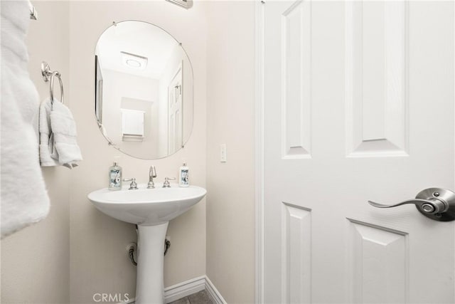 bathroom featuring baseboards and a sink