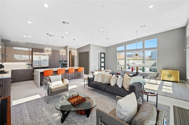 living room featuring an inviting chandelier, light tile patterned floors, visible vents, and recessed lighting