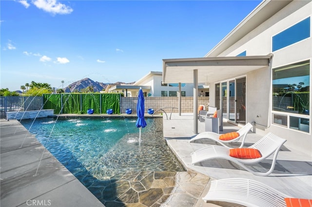 view of swimming pool featuring a fenced in pool, a mountain view, fence, and a patio