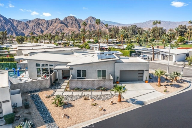 view of front of house featuring stucco siding, an attached garage, a mountain view, and concrete driveway