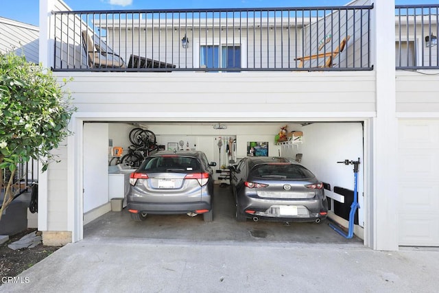 garage featuring washer / clothes dryer and concrete driveway