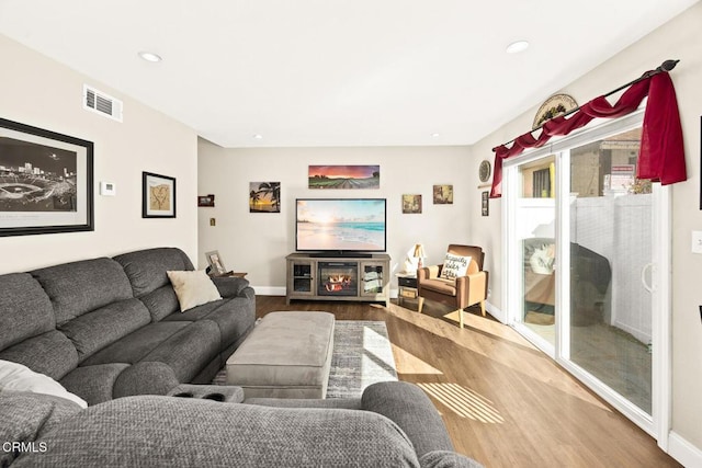 living room featuring baseboards, wood finished floors, visible vents, and recessed lighting