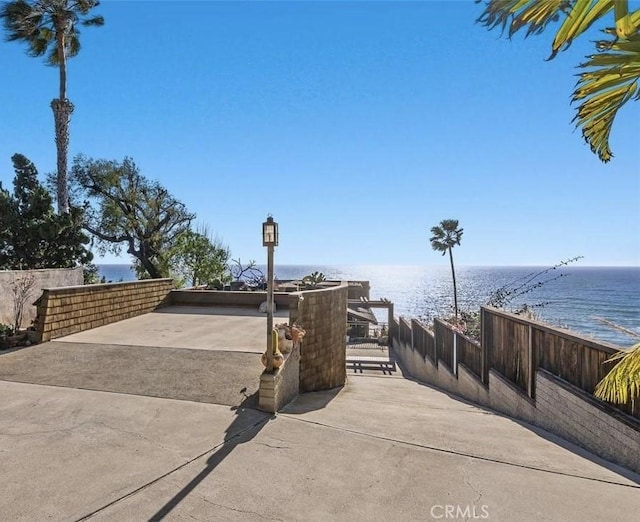 view of property's community with a water view and fence