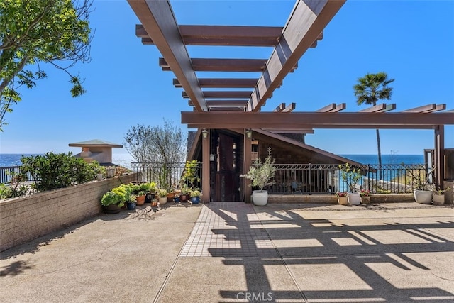 view of patio / terrace with a water view and fence