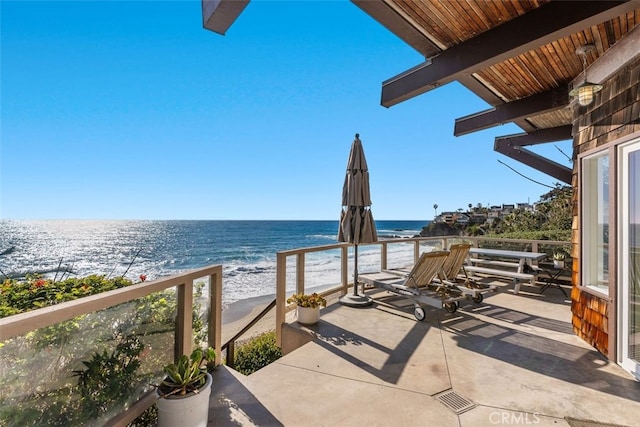 view of patio featuring a water view and a view of the beach