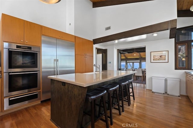 kitchen featuring visible vents, dark wood-style floors, appliances with stainless steel finishes, a sink, and a warming drawer