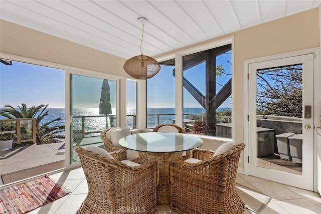 sunroom featuring a water view