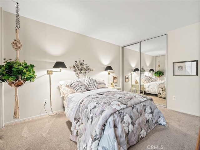 carpeted bedroom featuring baseboards and a closet