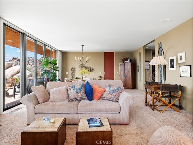 living room with carpet, a chandelier, and a wall of windows