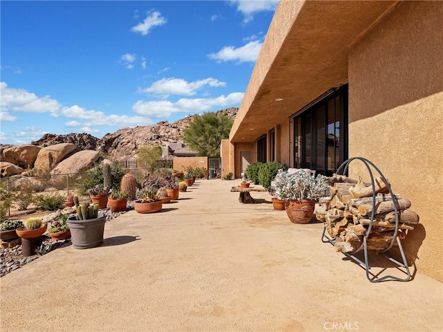 view of patio / terrace featuring fence and a mountain view