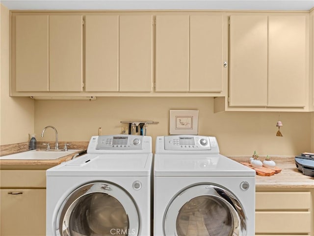 laundry room with cabinet space, a sink, and separate washer and dryer